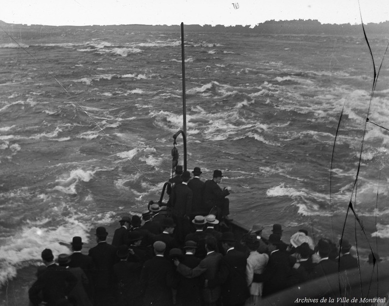 1910?-Photographie d'un groupe de personnes se tenant à l'avant d'un bateau naviguant sur les Rapides de Lachine