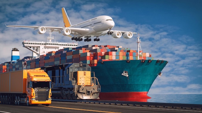 Shipping containers in boat with plane overhead.