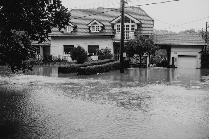 Black and white flooded home and street.