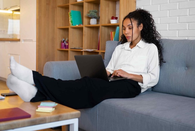 Woman on couch using a laptop computer